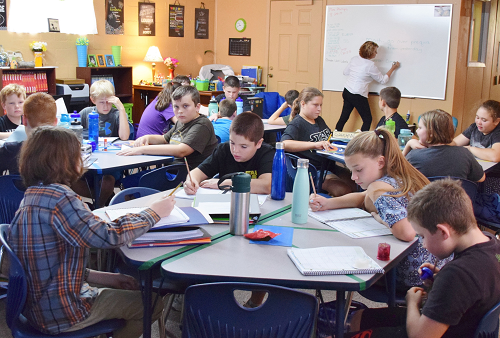 Students working together at table. Students working together at table.